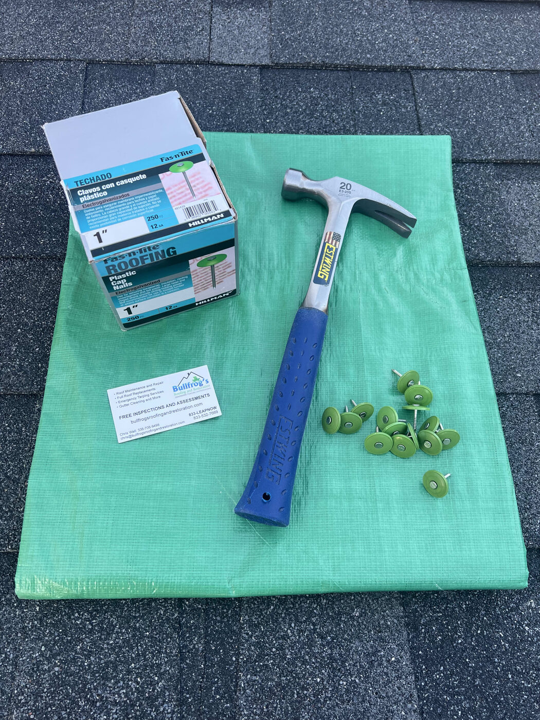 Roofing hand tools and materials laid out on a job site
