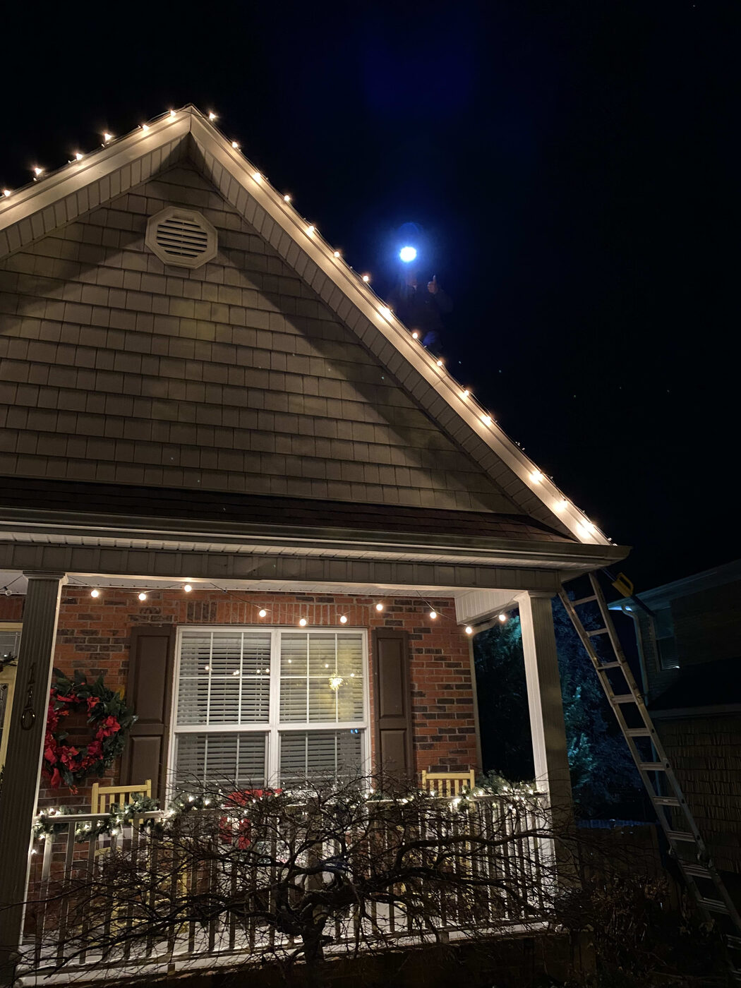 Home with roofline holiday lighting installed at night